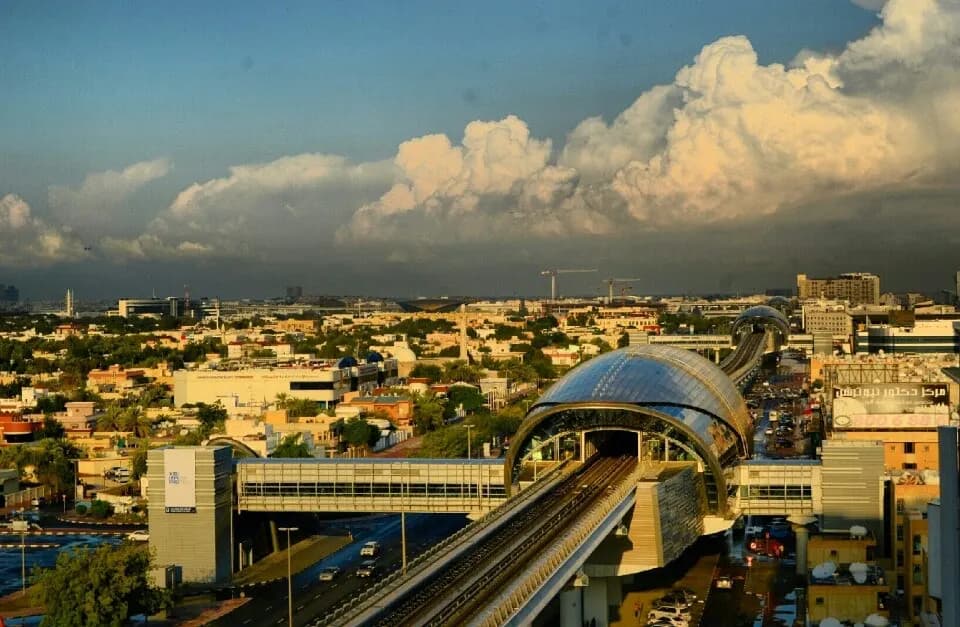 Elevated Dubai Metro station and viaduct in the airport district of Dubai with low-rise buildings beyond