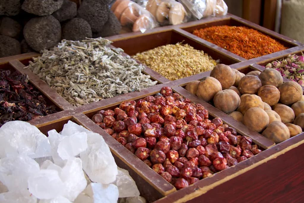 Trays of dried spices, rosebuds and rock sugar for sale in Dubai's spice souk