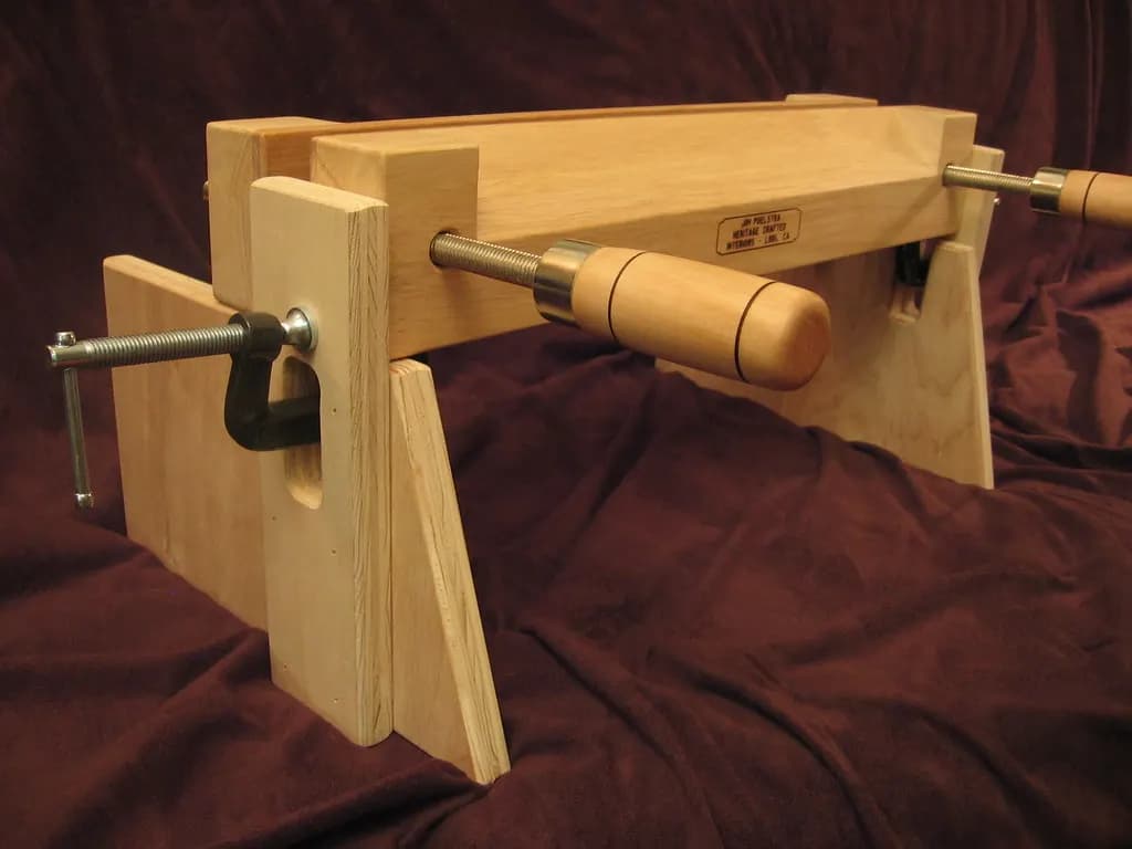 A bookbinder's lying press on a wooden stand used for finishing book spines
