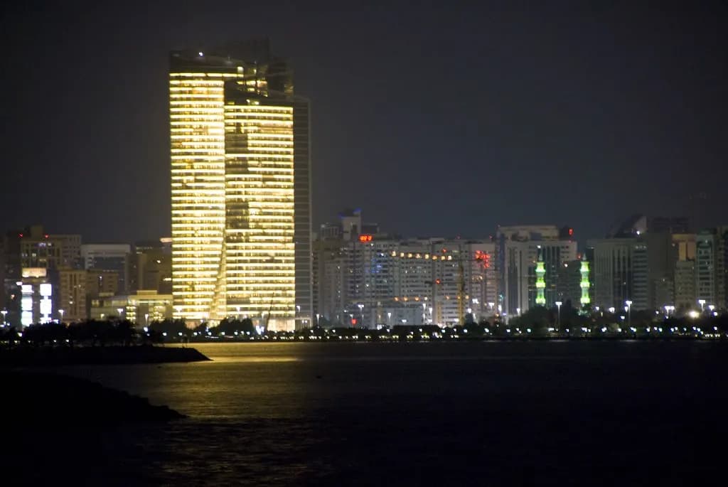 Abu Dhabi skyline lit up at night across the water from the Corniche