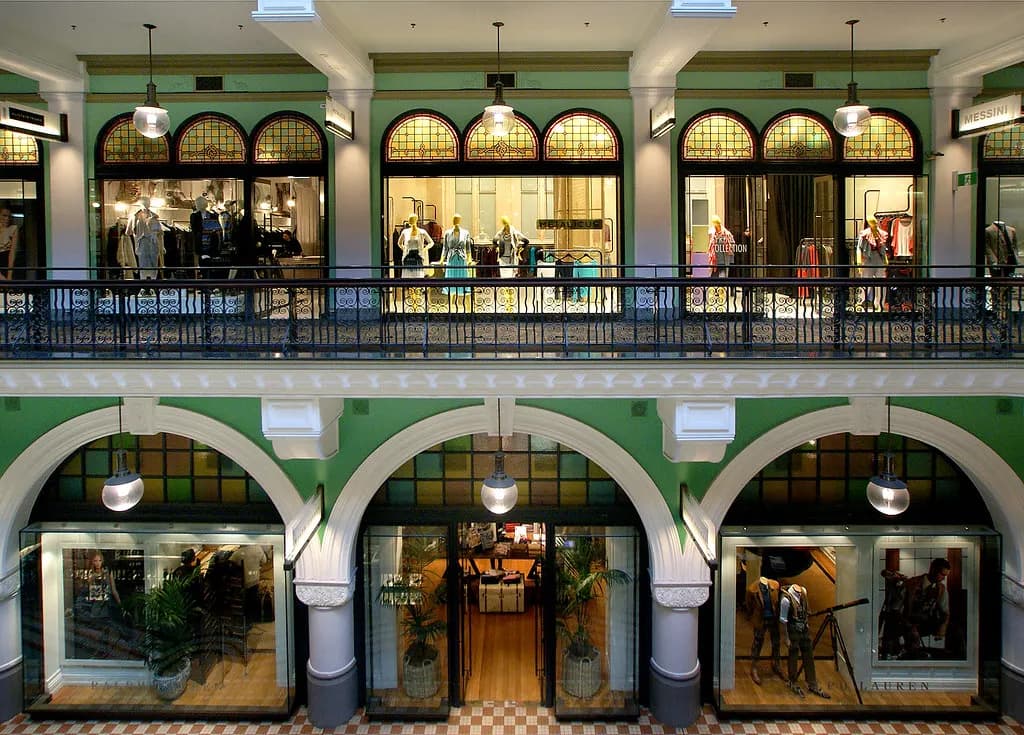 Two levels of small shopfronts under arched windows inside the Queen Victoria Building arcade in Sydney