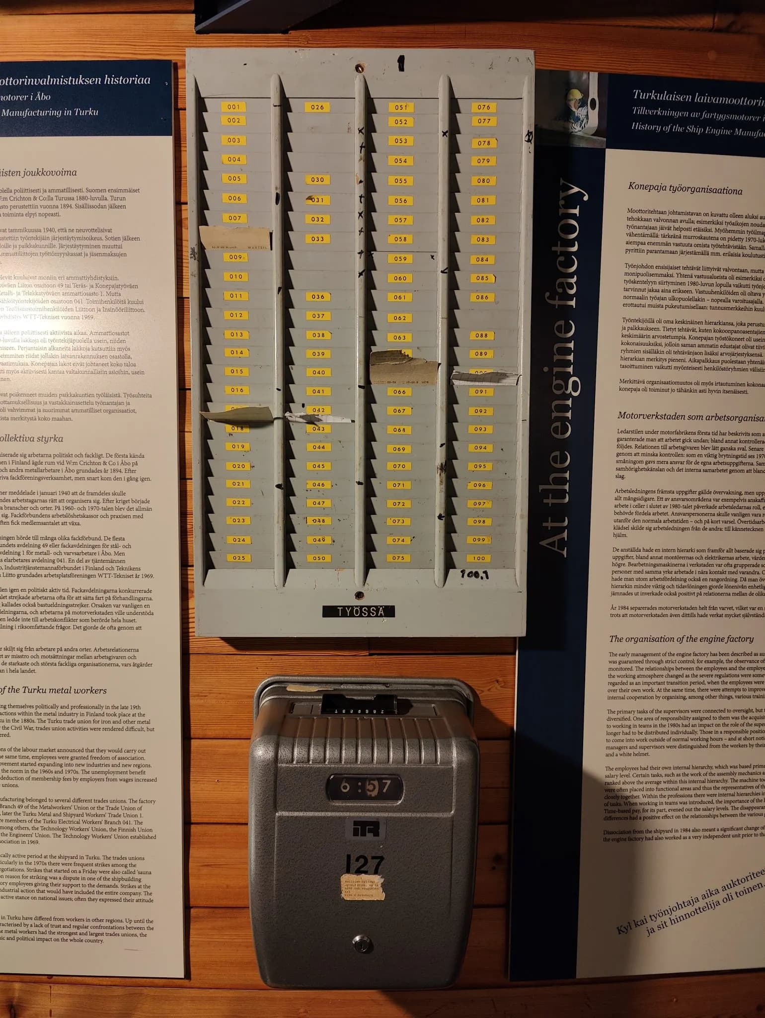 An old punch clock and a rack of time cards on display