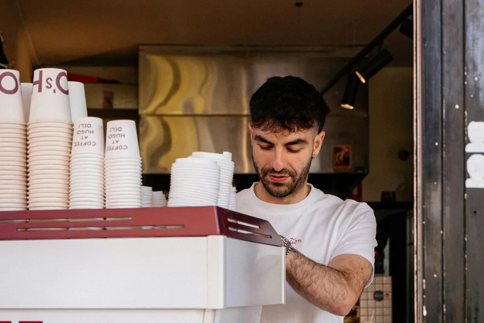 Barista making coffee behind the counter of a small takeaway coffee window in Melbourne