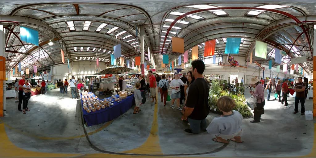 Shoppers walking between food and craft stalls inside the Old Bus Depot Markets in Kingston, Canberra