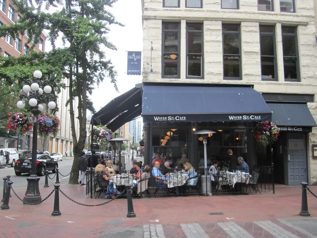 A sidewalk cafe with patio tables on a brick street in Gastown, Vancouver