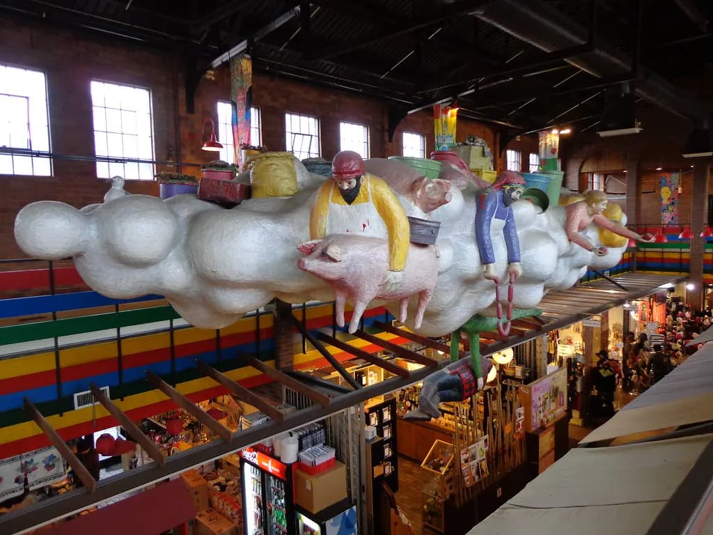 Interior of the ByWard Market building in Ottawa with small vendor stalls under colourful sculptures