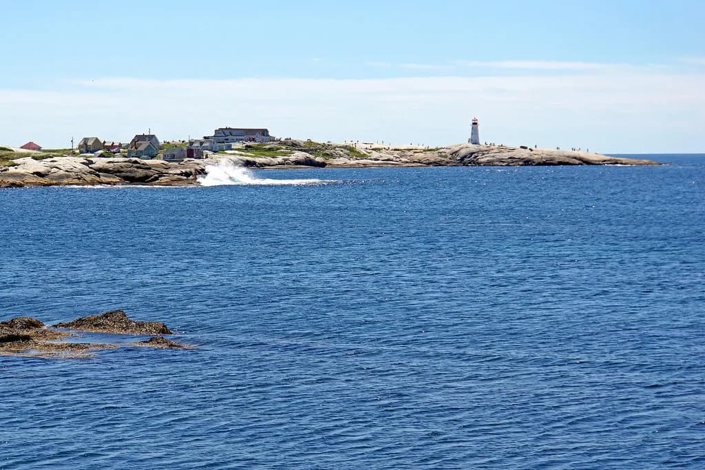 Granite shoreline and lighthouse at Peggy's Cove across St. Margarets Bay, Nova Scotia