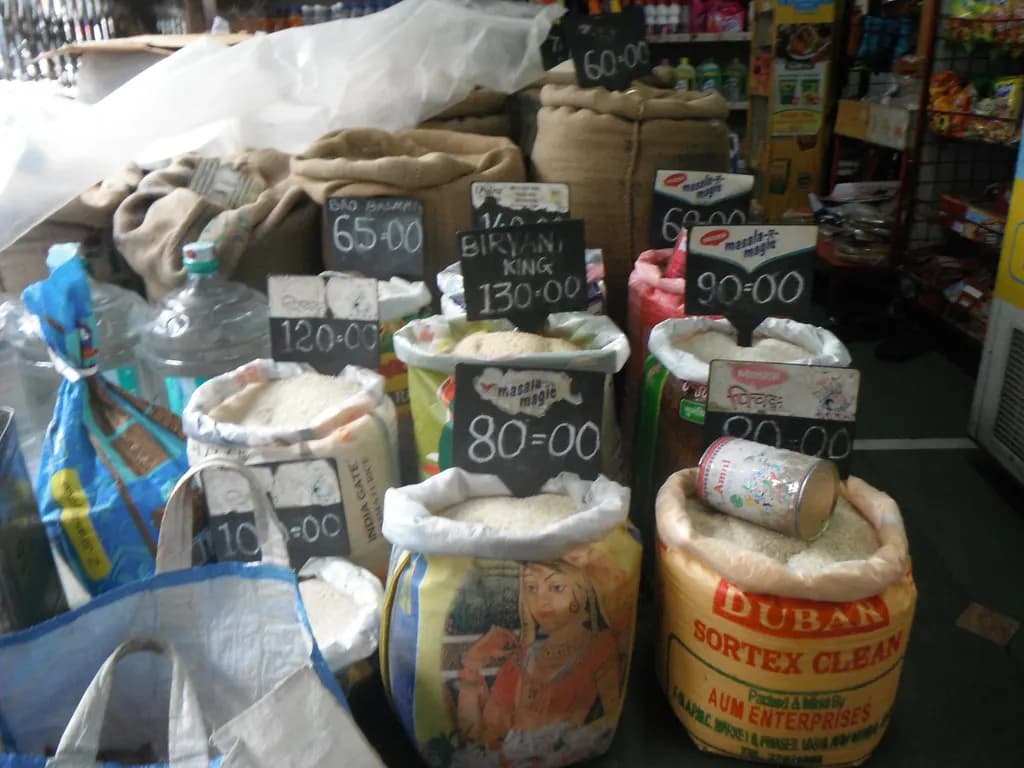Open sacks of rice with price boards in an Indian grocery shop