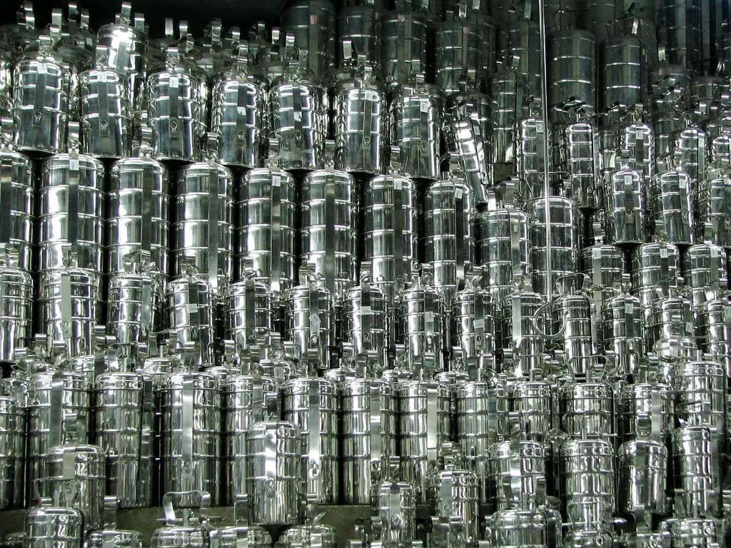 Floor-to-ceiling stacks of stainless steel tiffin carriers and containers in a Chennai utensil shop