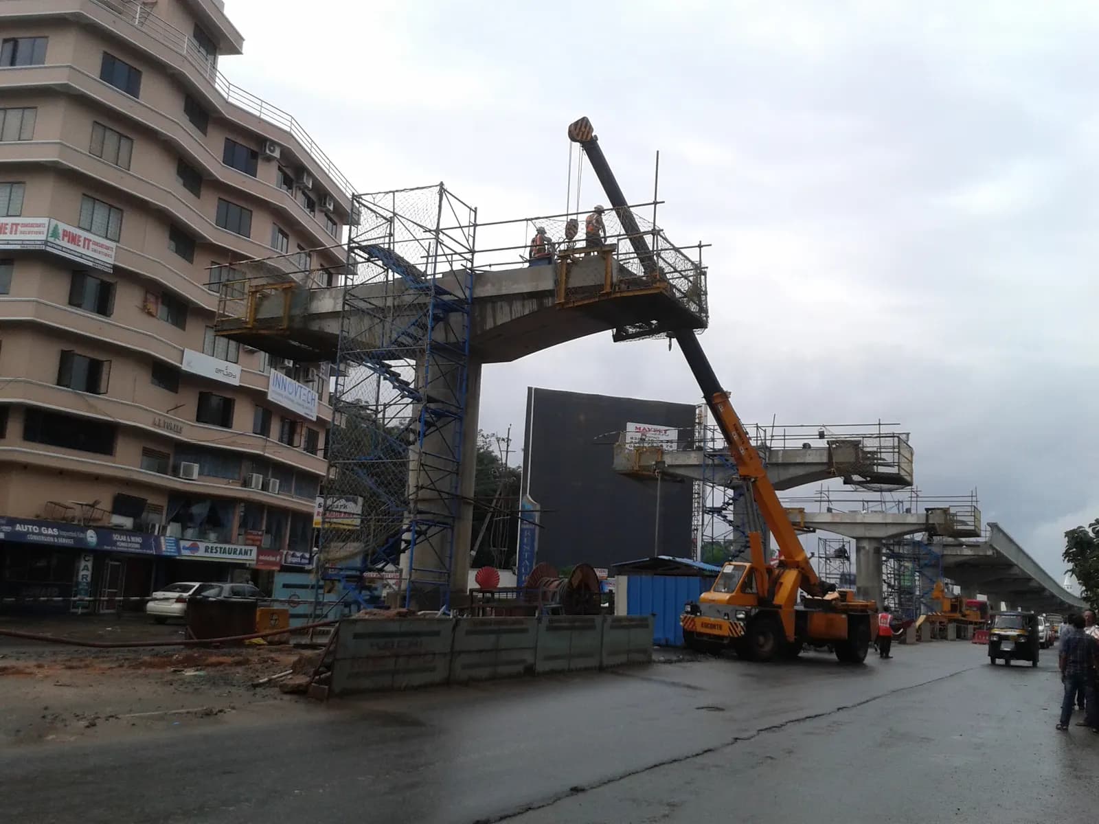 Kochi metro construction site with girders and workers on the viaduct