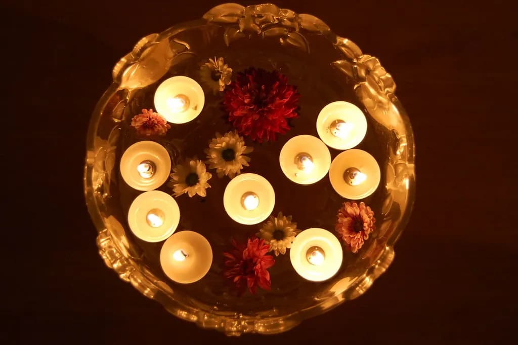 Tealight candles floating with flowers in a glass bowl for Diwali