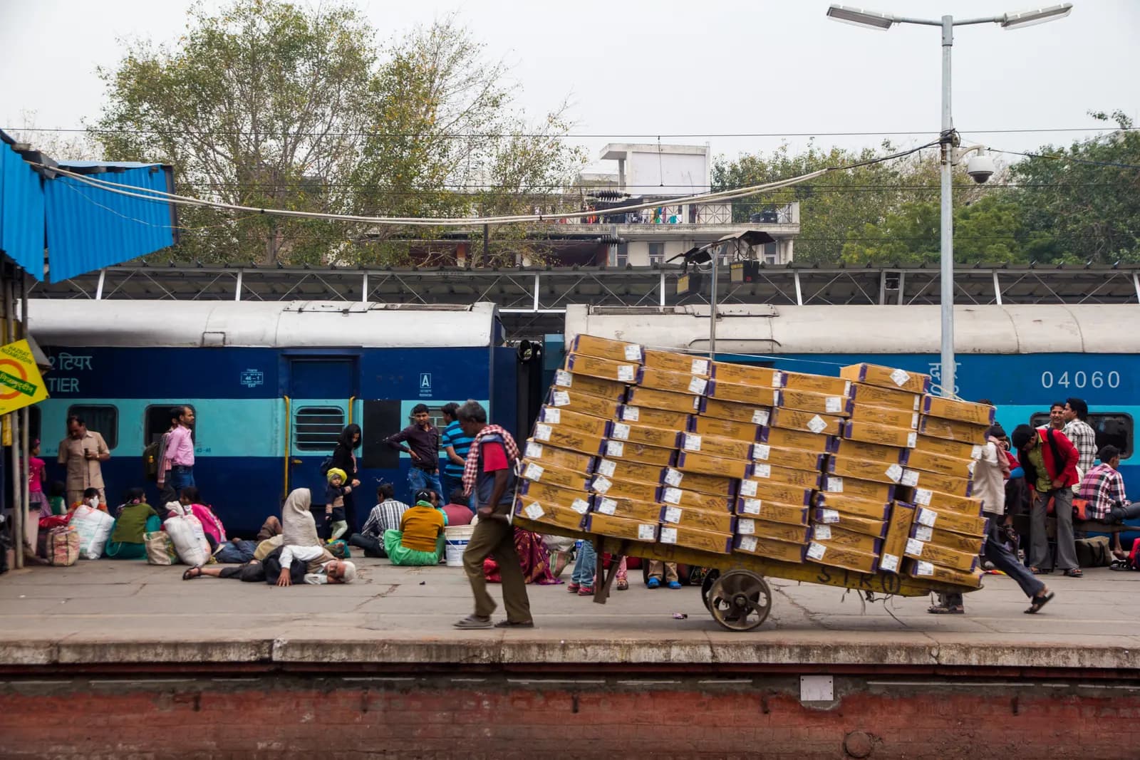 A porter carrying luggage on the platform at Hazrat Nizamuddin railway station in Delhi
