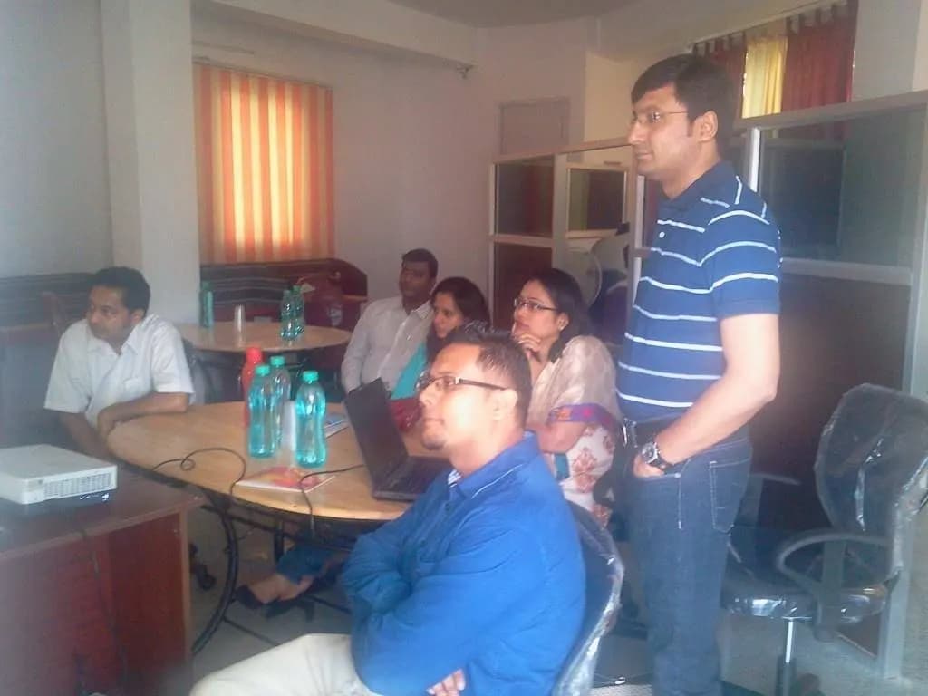 A startup team meeting around a table with laptops in a Bangalore coworking hub