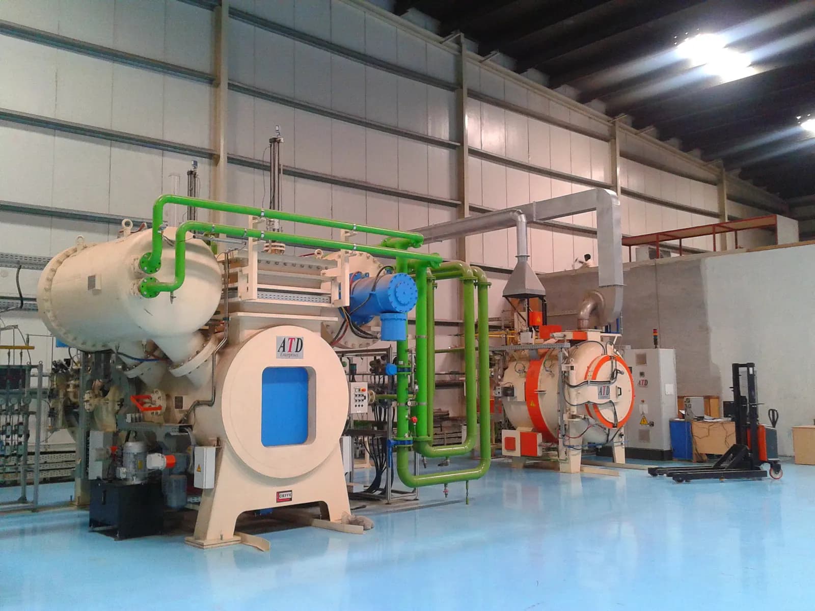 Computer-controlled vacuum heat treatment furnaces with gas-quench piping in a clean industrial hall