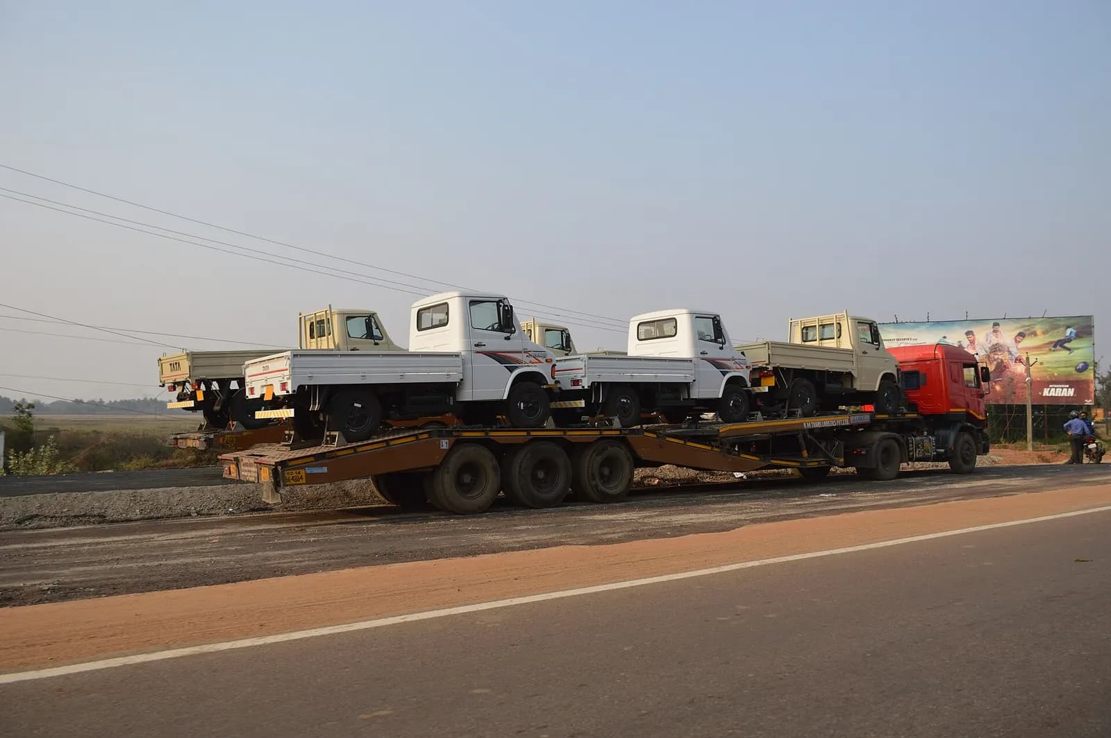 New light commercial trucks being carried on a trailer truck along National Highway 16 near Bhubaneswar