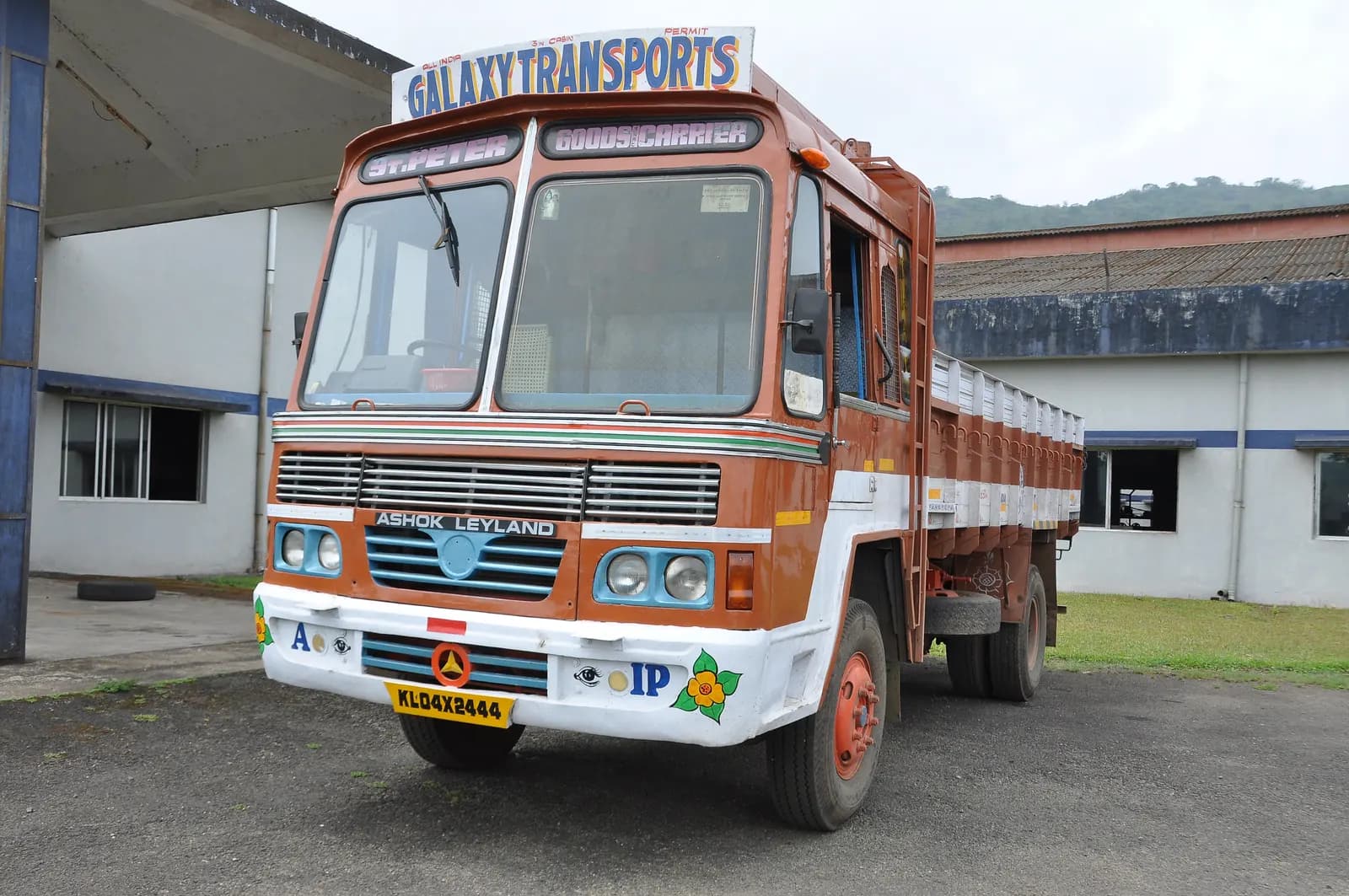 An Ashok Leyland goods lorry parked at a loading yard in India, waiting for its consignment