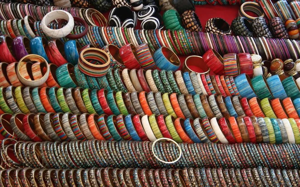 Stacks of colourful glass and lac bangles arranged in rows on a market display