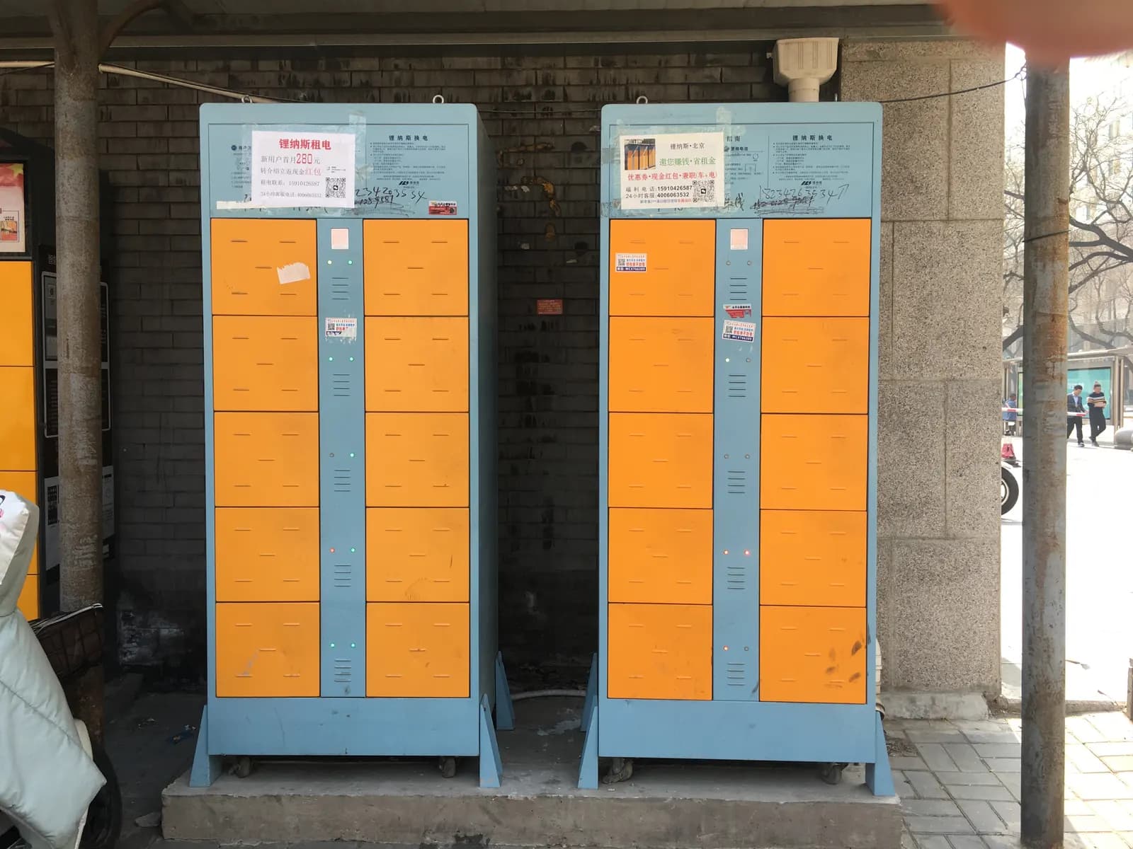 A roadside battery-swapping cabinet with rows of charging lockers for electric scooter batteries