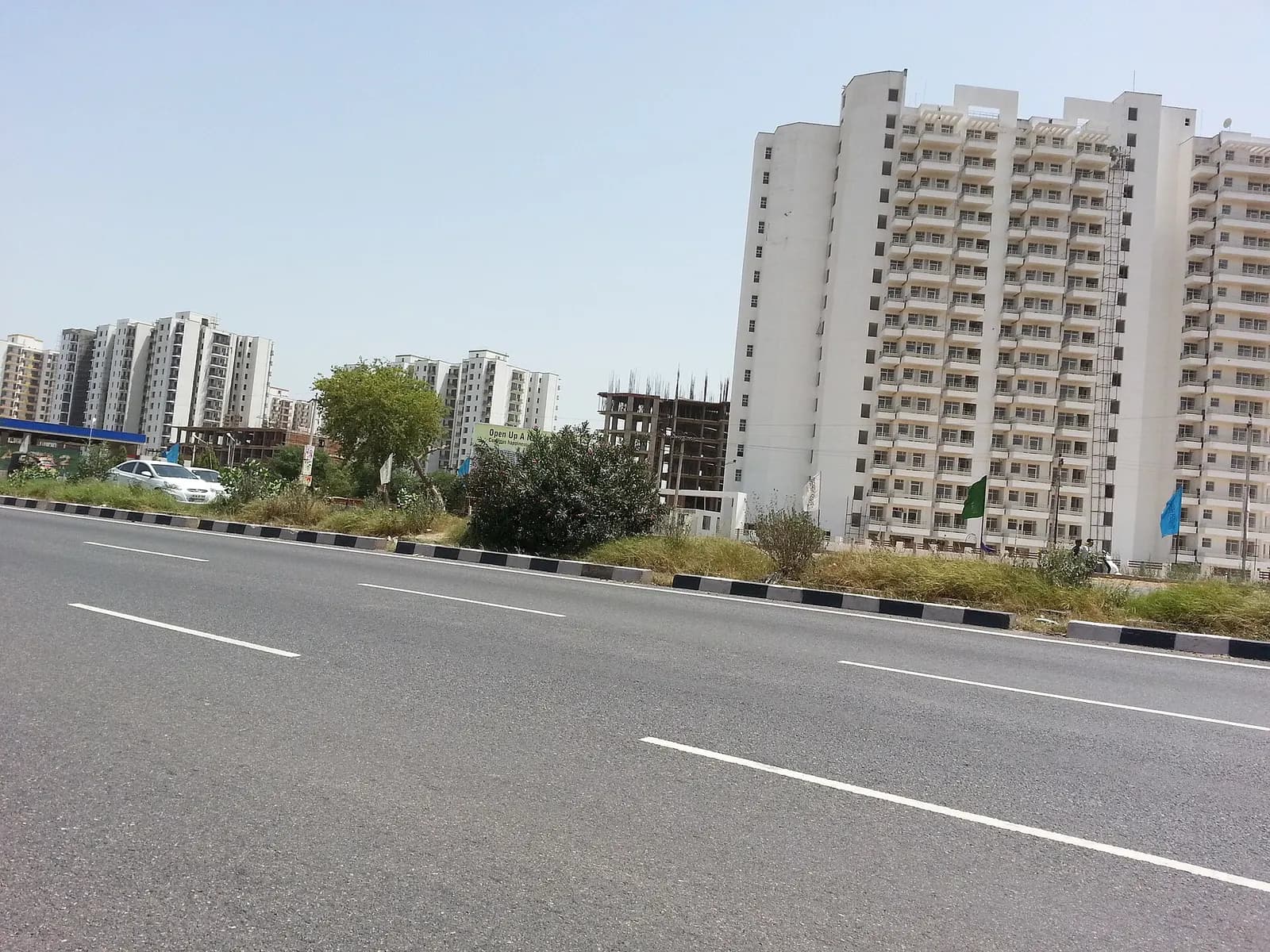 Residential apartment blocks under construction along a wide city road