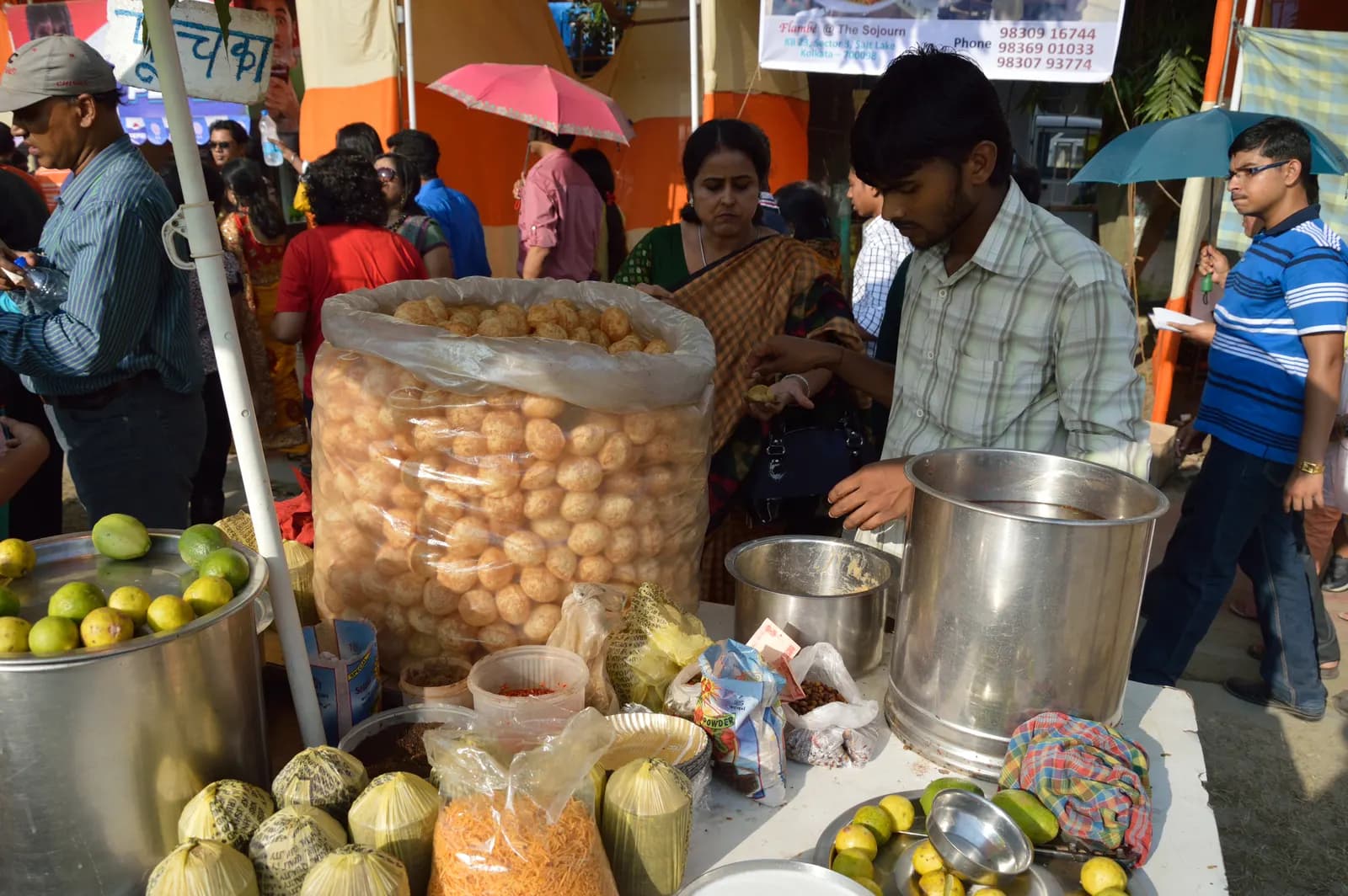 A pani puri street stall in Kolkata with a vendor serving customers from a handcart