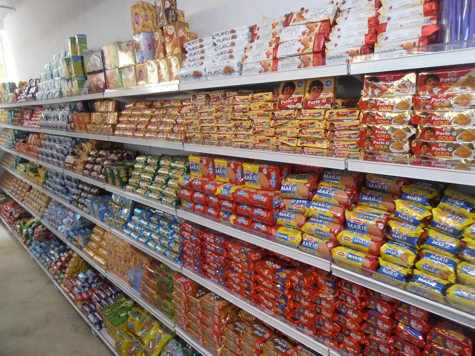 Shelves of packaged biscuits in an Indian supermarket aisle
