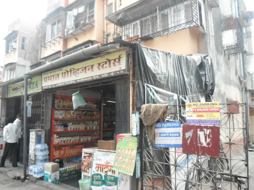A small provision store in Mumbai with shelves of packaged groceries and bottled water stacked at the entrance