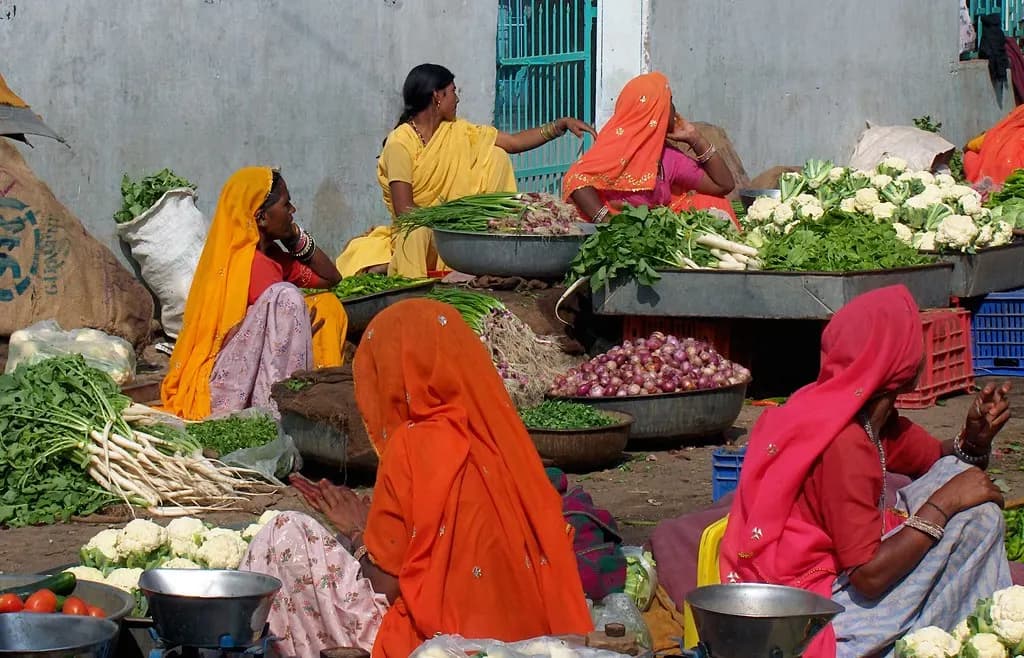 Women selling fresh vegetables, cauliflower and greens at an open-air market in Kuchaman, Rajasthan