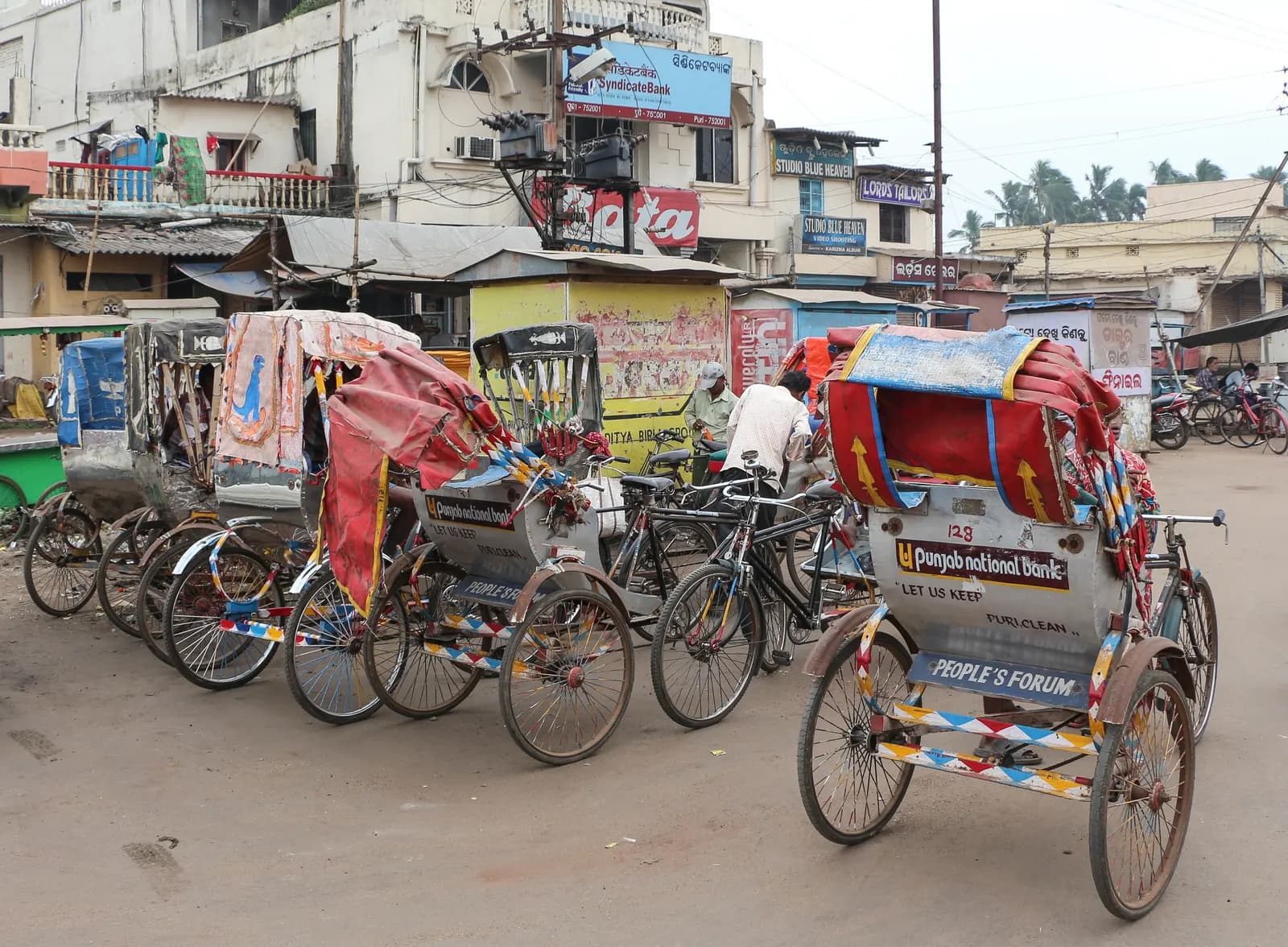 A row of cycle rickshaws parked on a street in Puri, Odisha