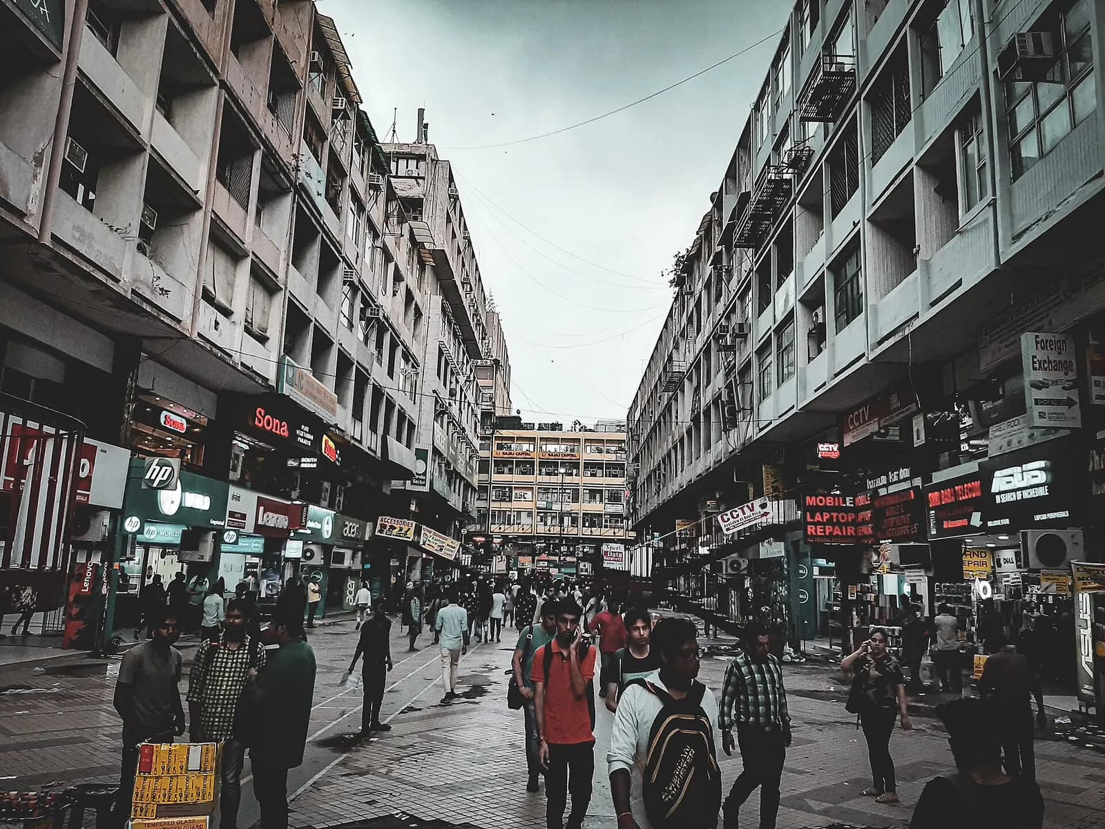 Shoppers walking through Nehru Place market in Delhi, lined with computer, laptop and CCTV shops