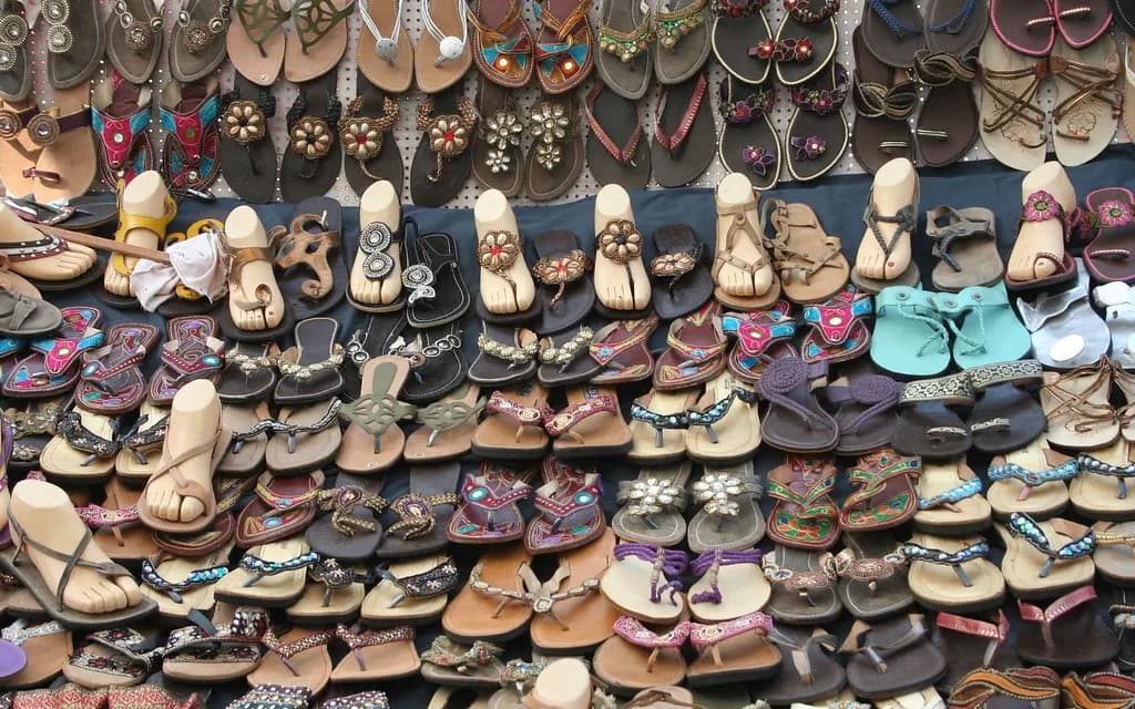 Hundreds of women's sandals and flip-flops in many colours arranged in rows on a shop display