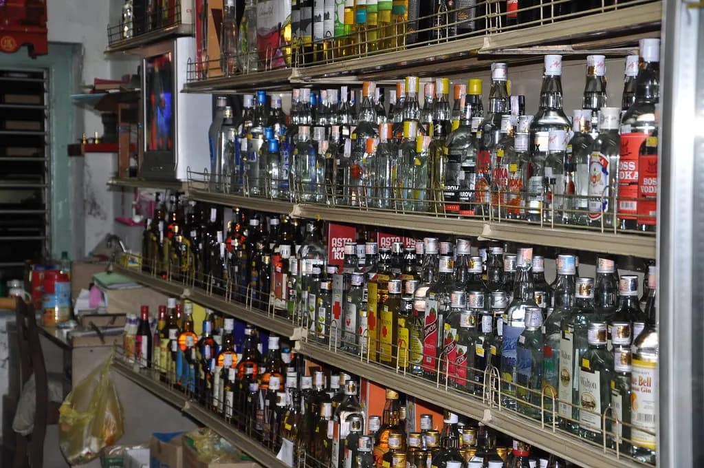 Shelves of a liquor shop in India stacked with bottles of whisky, rum and other spirits