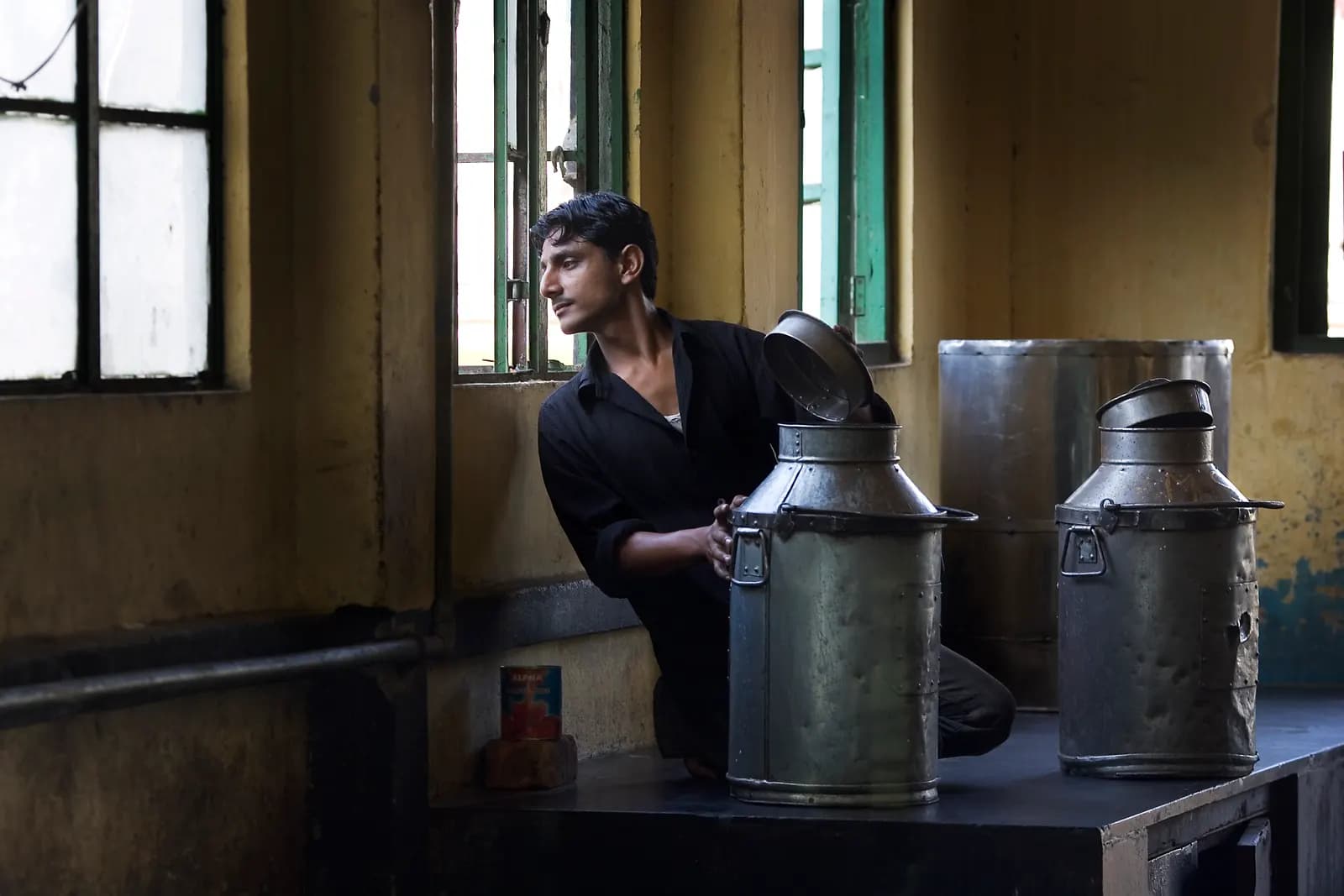 A milkman in Kolkata beside steel milk cans