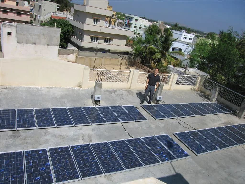 Rows of solar panels on the flat concrete roof of an office building in Kuppam, Andhra Pradesh
