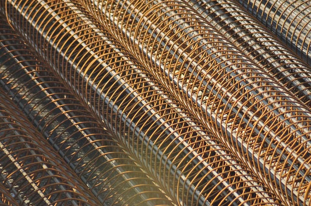 Steel reinforcement cages of straight bars and spiral links stacked at a construction site