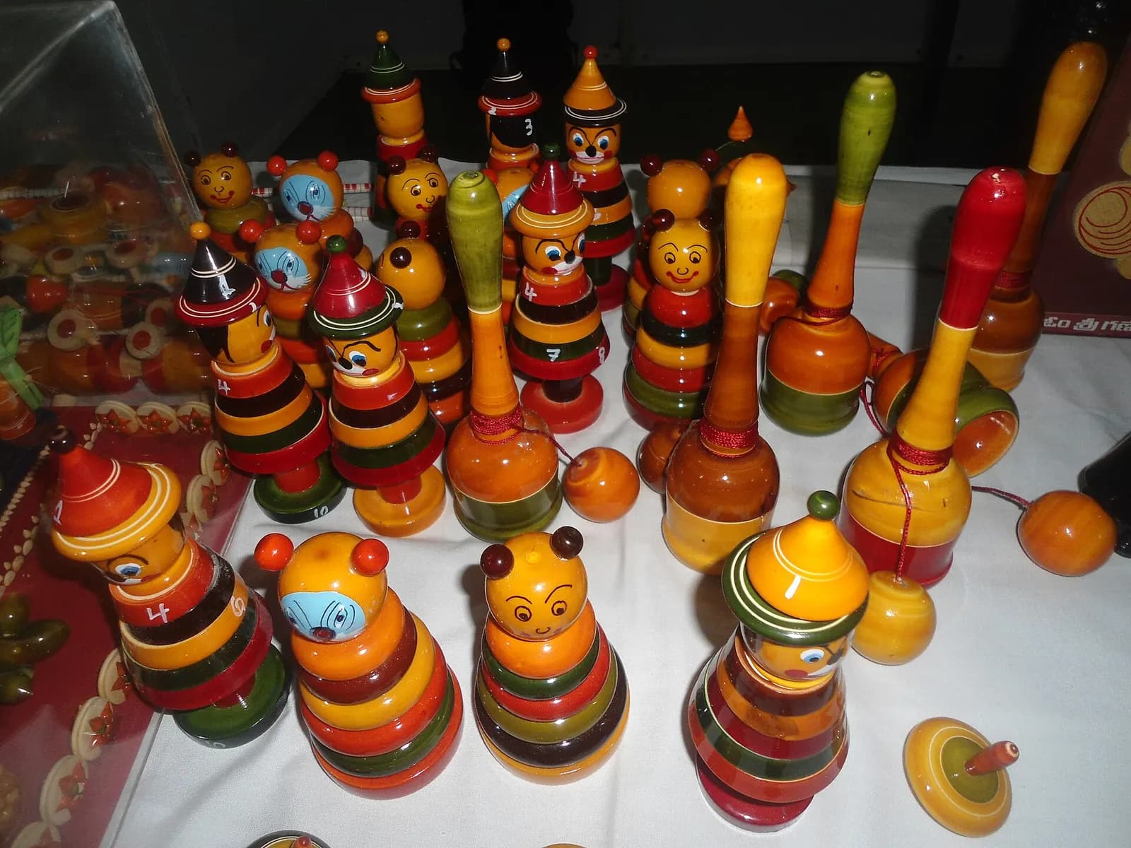 Brightly lacquered Etikoppaka wooden toys, stacking dolls and spinning tops displayed on a table