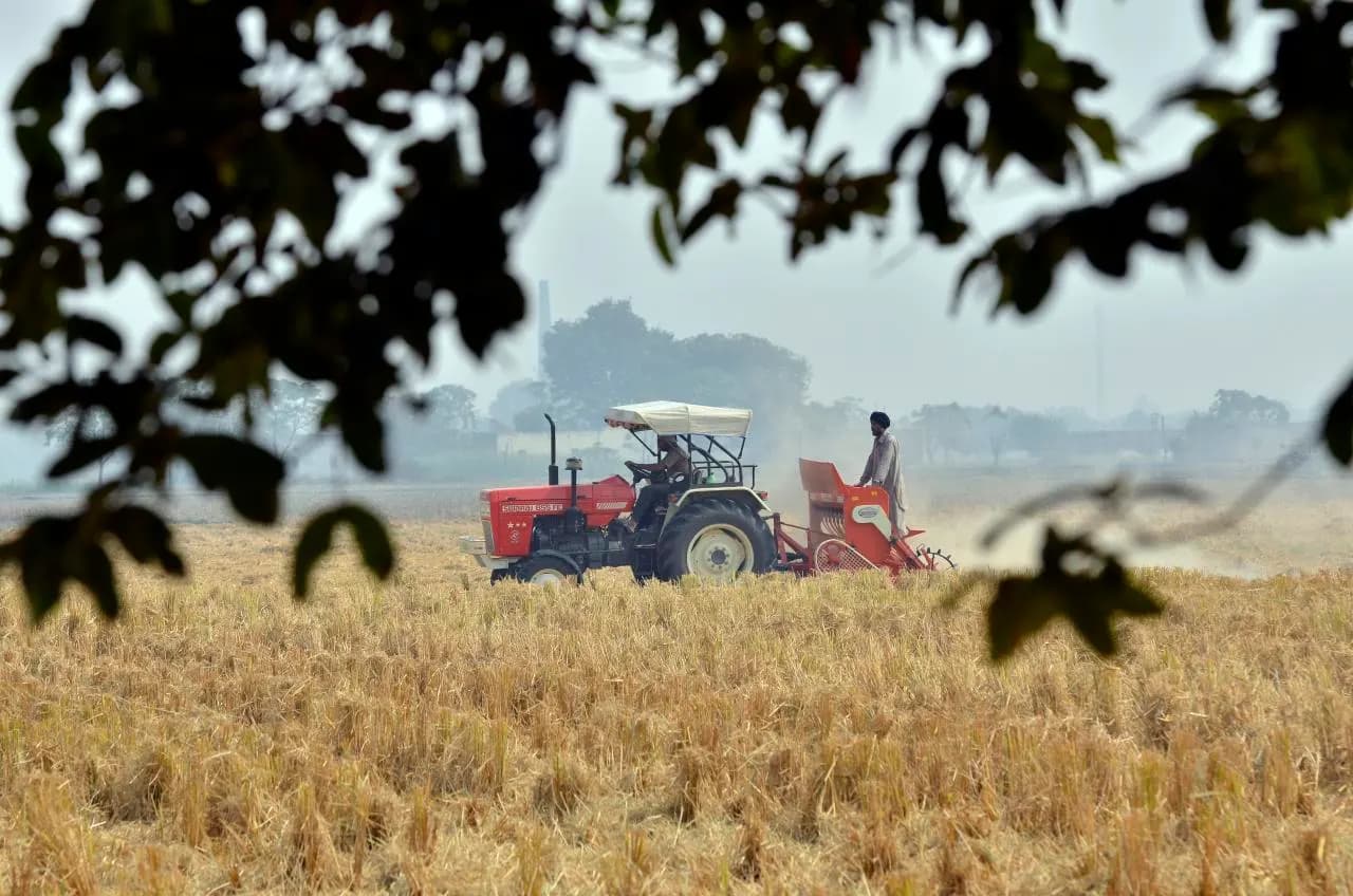 A tractor pulling a seed drill through rice stubble to sow wheat in Punjab
