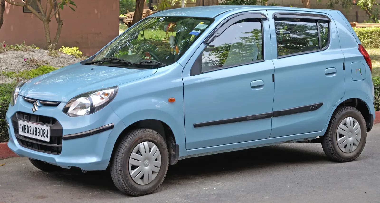 A silver small hatchback parked on a roadside in Kolkata