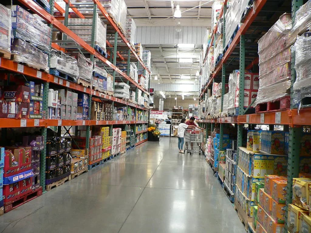 Long aisle of tall warehouse shelves stacked with boxed stock