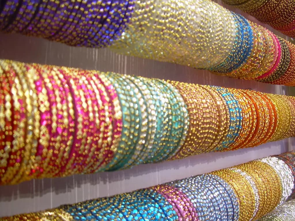 Rows of glittering glass bangles stacked on display rods in a Delhi shop