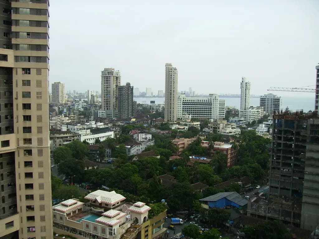 Residential towers and low-rise housing in Mumbai with the sea in the distance