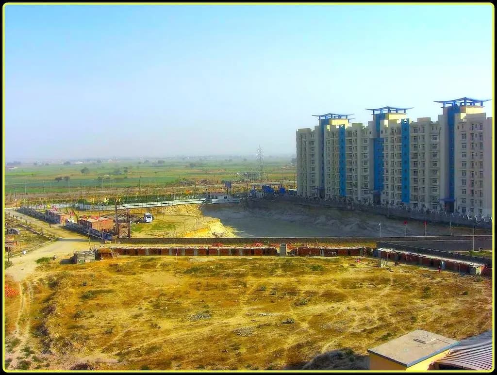 New apartment blocks beside open land being levelled for development on a city's edge