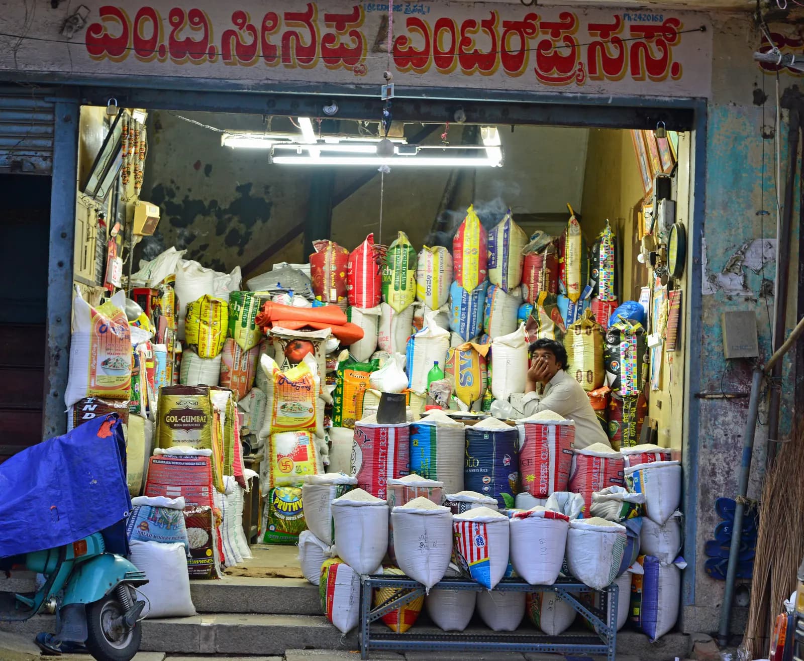 A rice and grain shop in Santhepet, Mysuru, with sacks of rice stacked at the entrance and a Kannada shop sign above