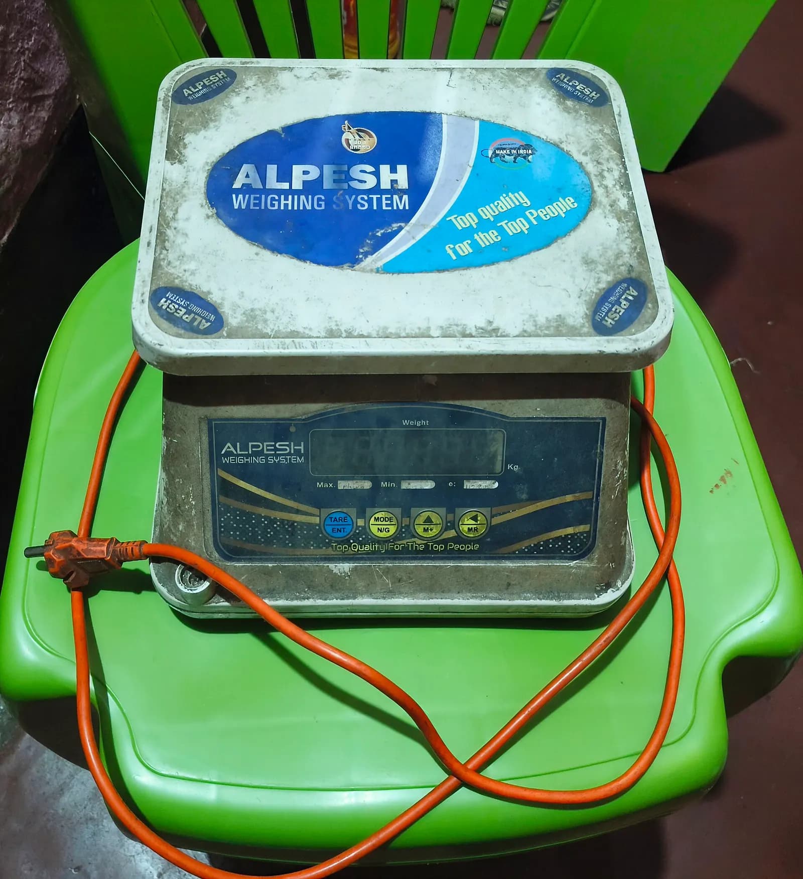 An electronic weighing scale on a shop counter in India showing a digital weight display