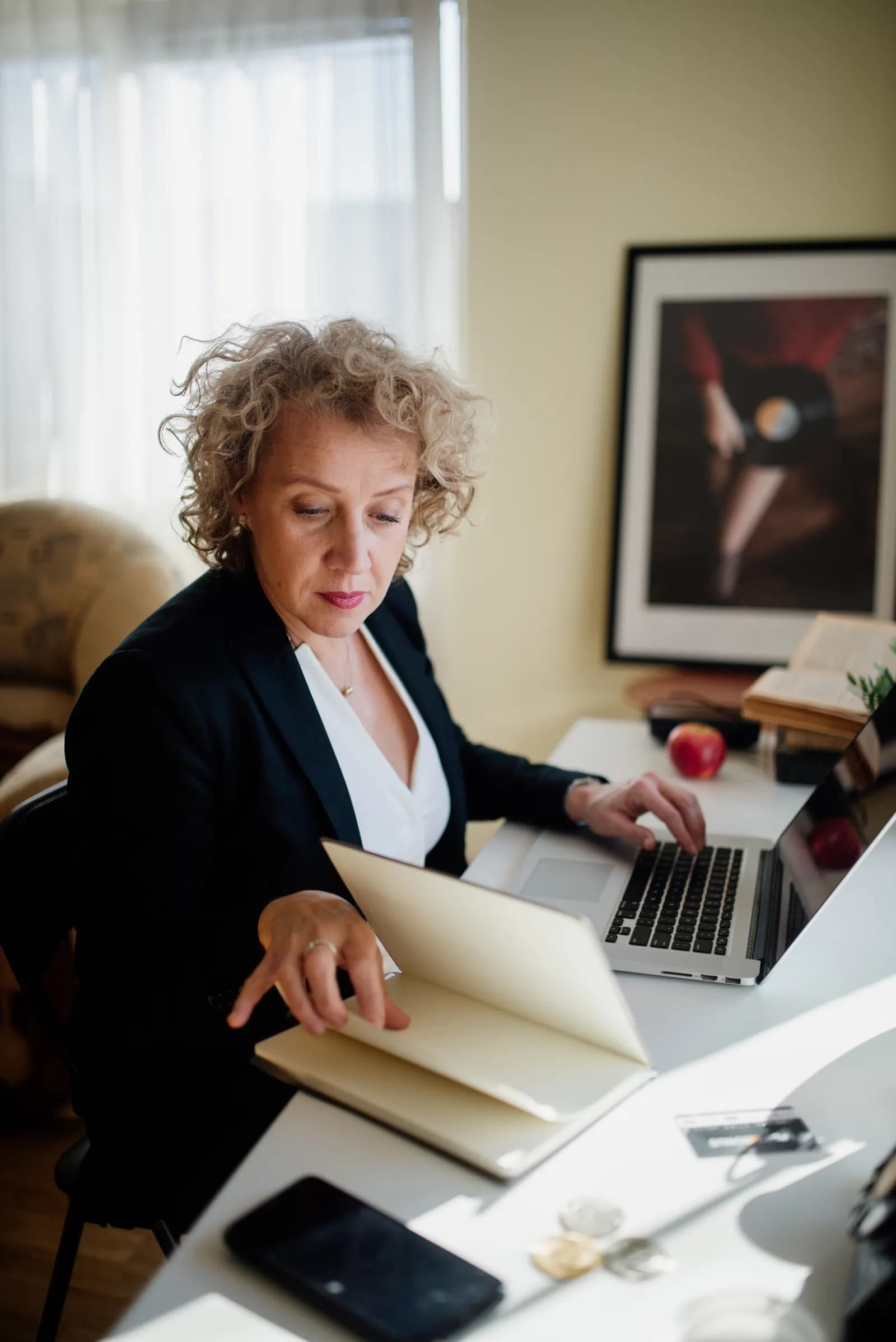 Professional working at a desk with a laptop and printed documents