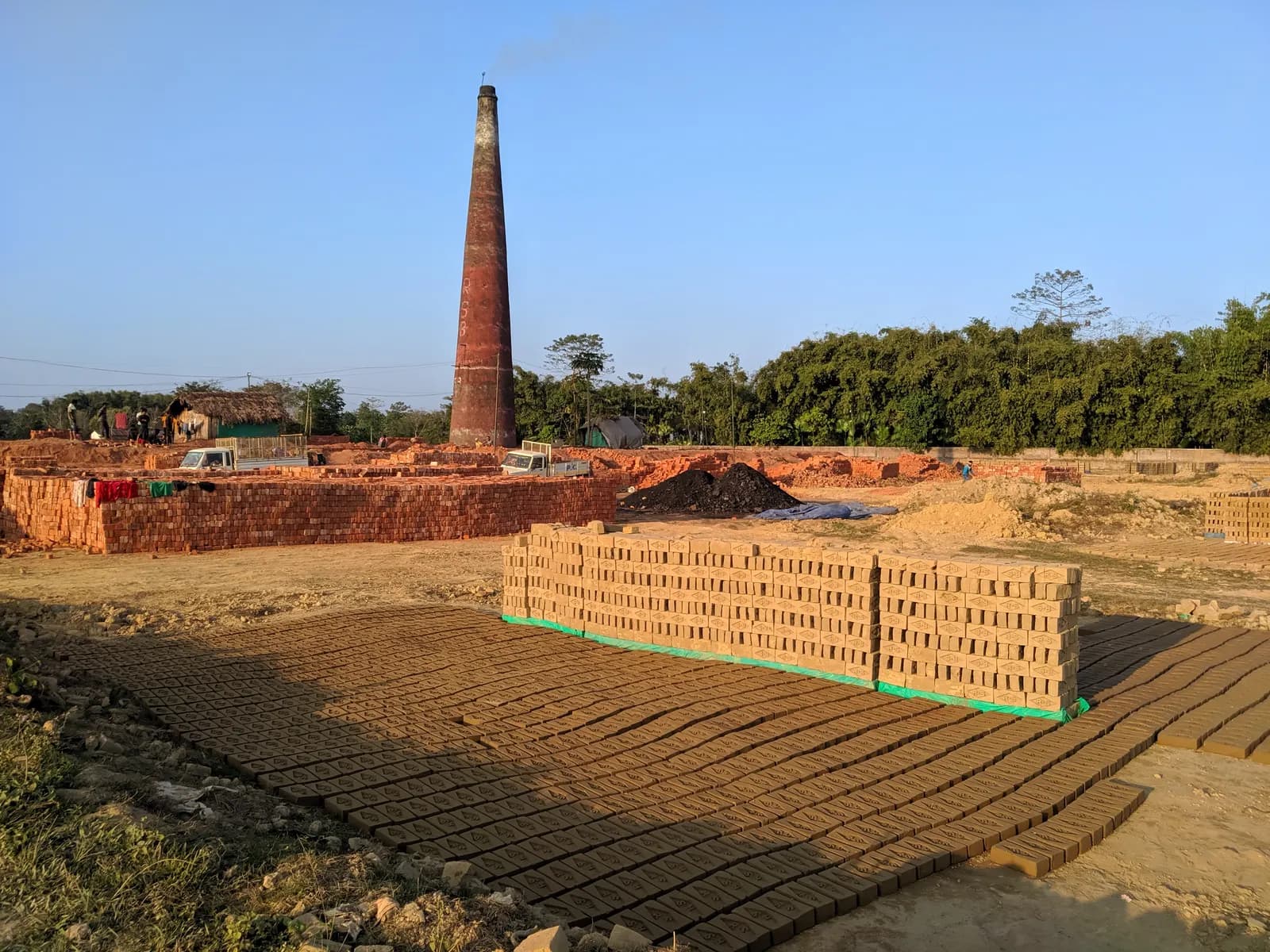 A brick kiln chimney and stacks of fired bricks in Tinsukia district, Assam