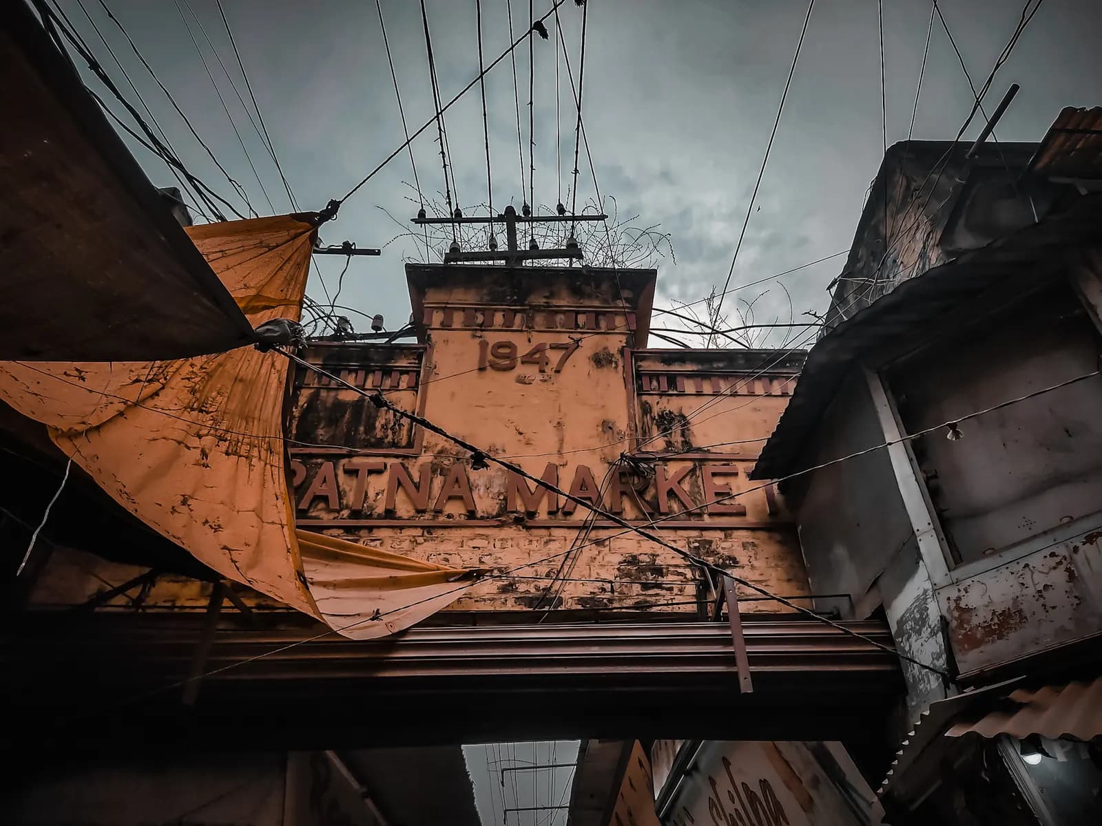 The old entrance arch of Patna Market, dated 1947, with shop awnings on either side