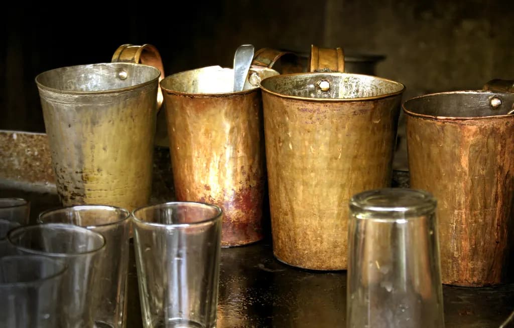 Brass tea jugs and glass tumblers at a small tea stall in Kerala