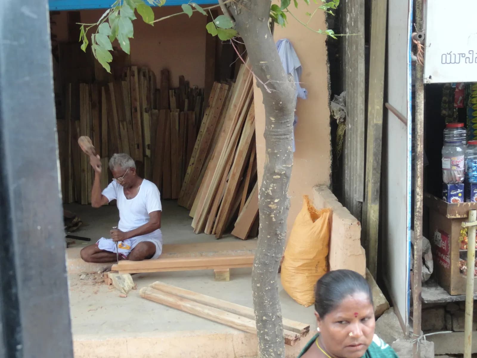A carpenter planing a wooden plank in his workshop at Chandragiri, Andhra Pradesh