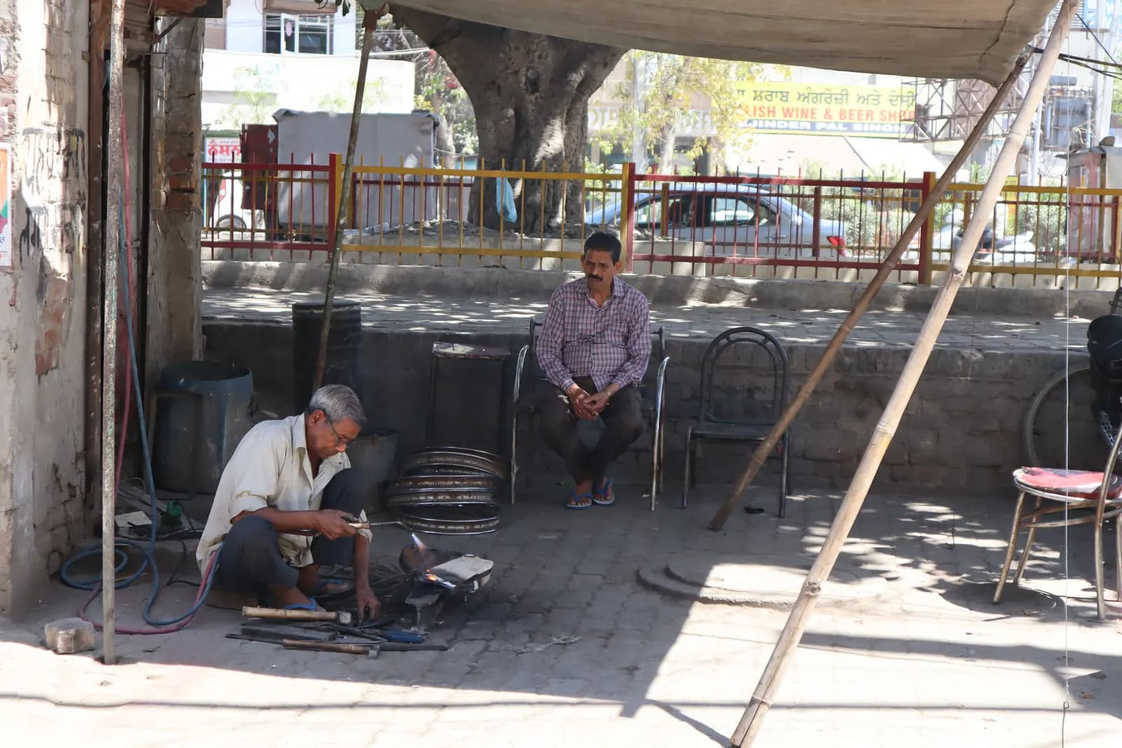 A welder working with portable equipment at a roadside workshop in Amritsar, Punjab