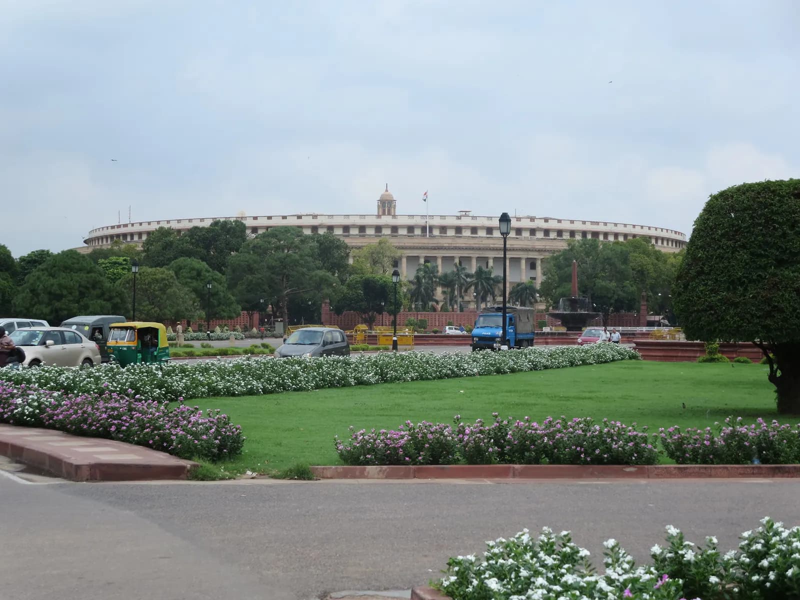 The circular old Parliament House (Sansad Bhavan, now Samvidhan Sadan) in New Delhi behind lawns and flower beds